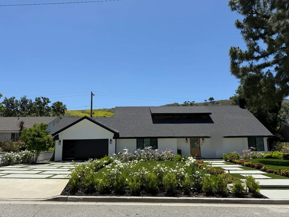 A finished front yard with flower beds in front of a single-story house