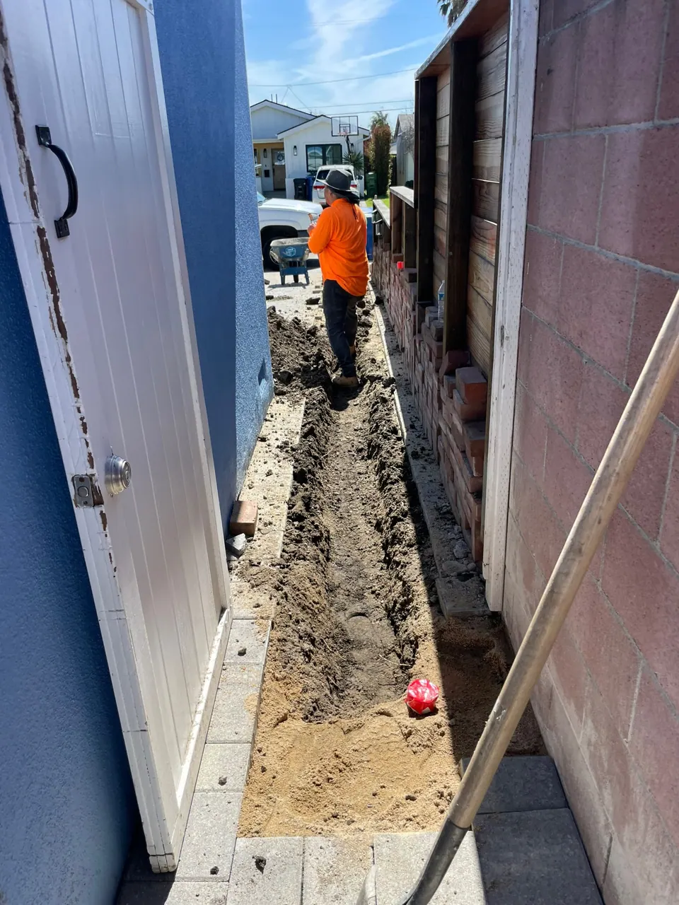 A drain trench dug along the side of a house
